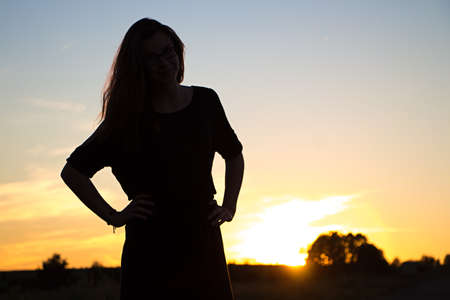 Beautiful teenager girl with glasses in the light of sunsetの写真素材
