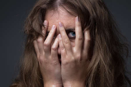 Frightened girl in water droplets on grey backgroundの写真素材