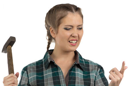 Photo of young woman hit with a hammer on forefingerの写真素材