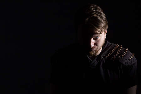 Photo of blond man with stern look on black backgroundの写真素材