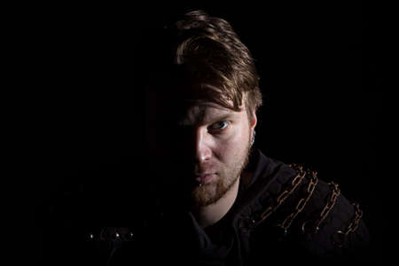 Image of blond man looking at camera on black background