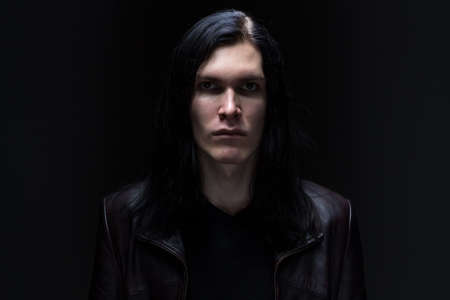 man looking at camera on black backgroundの写真素材