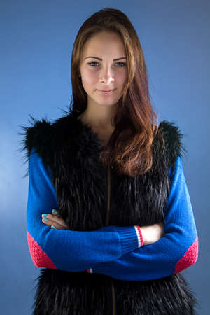 Photo of teenage girl with arms crossed on blue background