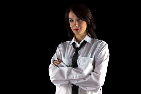 Photo of young woman wearing mans shirt on black backgroundの写真素材