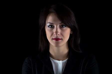 Portrait of brunette business woman on black background