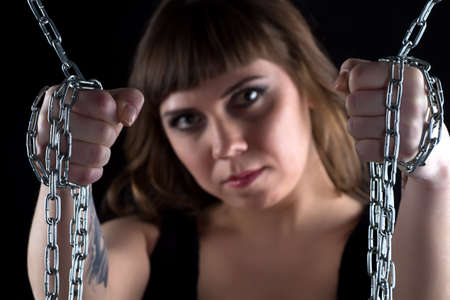 Portrait of woman with chains on black background