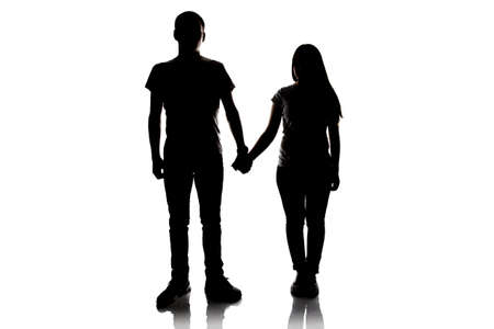Silhouette of teenagers holding hands on white backgroundの写真素材