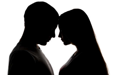 Silhouette of two loving teenagers on white backgroundの写真素材