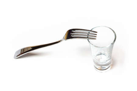 Photo of one glassy shot and fork on white background