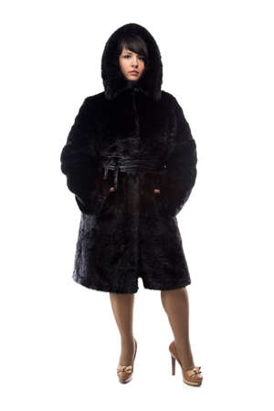 Photo of pudgy woman in black coat with hood on white backgroundの写真素材