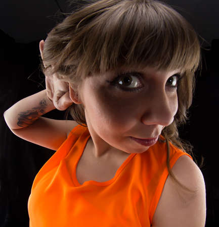 Photo of woman with hand near ear, fish eye on black background