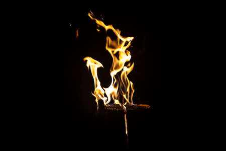 Photo of bright flaming log by night on black backgroundの写真素材