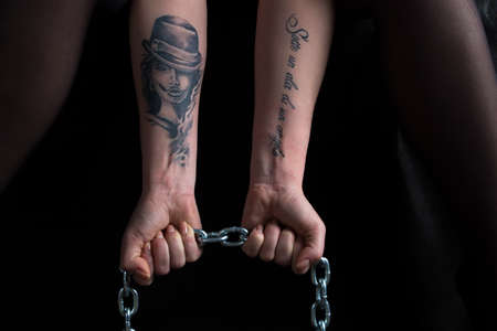Image of woman's hands holding chain on black backgroundの写真素材
