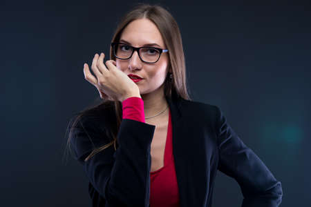 Photo of woman with hand near face on black backgroundの写真素材