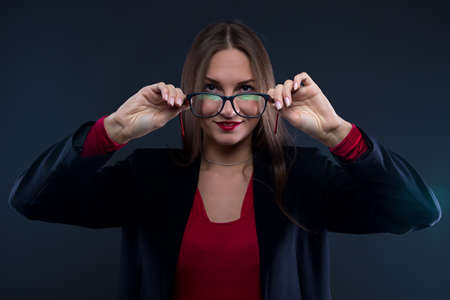 Photo of woman holding glasses on black background