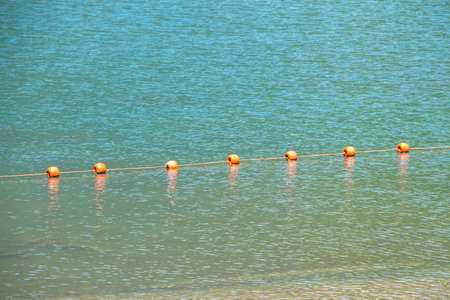 Photo of a mountain lake with buoys in the summerの写真素材