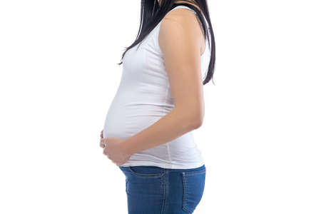 Young pregnant woman in profile, no face on white backgroundの写真素材
