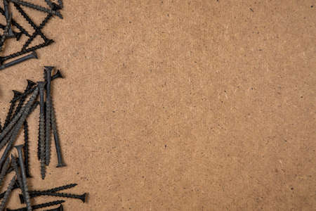 Background of black screws on wood plate