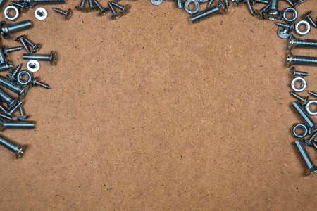 Background of bolts and nuts on wood plateの写真素材