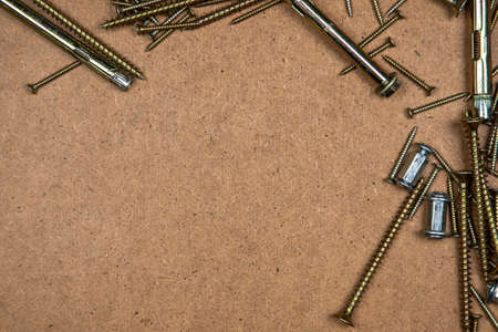 Background of gold screws on wood plateの写真素材