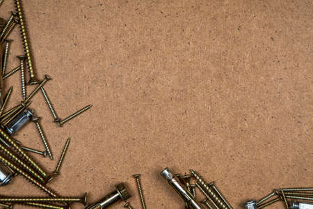 Background of gold screws on wood plateの写真素材