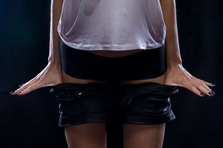 Undressing wet shorts woman on black background