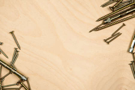 Gold screws on diagonal with wood background. Photo of construction background.の写真素材