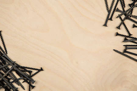 Screws on diagonal of plate. Construction background with tools.の写真素材