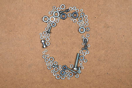Zero from bolts and nuts. Photo of mozaic sign on wood background.