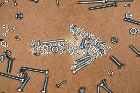 Bright right arrow from bolts and nuts. Photo of mozaic sign on wood background.の写真素材