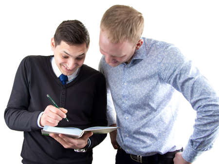 Two businessmans on white looking in book. Isolated photo with white background.の写真素材