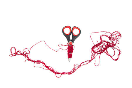 Scissors and red thread  on white background. Isolated photo of an object with white background.の写真素材