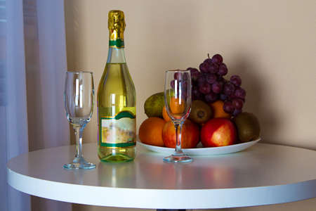 Bottle and glasses on the table. Photo of summer hotel complex.の写真素材