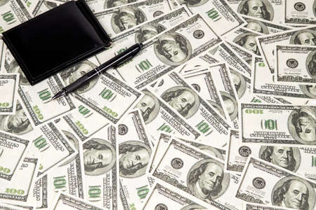 Background of a lot of hundreds dollars and pen. Photo of background.の写真素材
