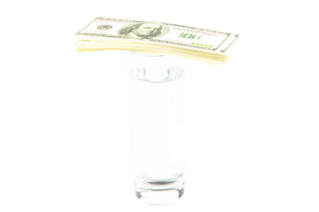 Glass of water and bundle of dollars. Isolated photo of an object.の写真素材
