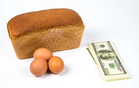 Expensive eggs, bread and dollars on white background