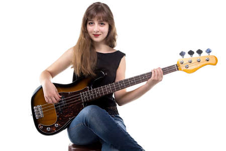 Teenage girl playing on bass guitar on white background