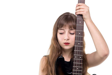 Sad teenage girl holding a guitar on white background