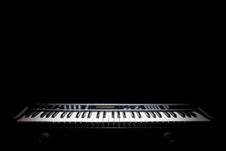 Piano in shadow, music on black backgroundの写真素材