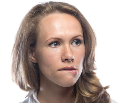 Blond woman biting her lip on white backgroundの写真素材