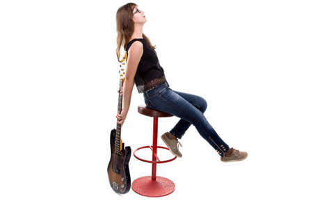 Teenage girl with guitar sitting on bar stool on white backgroundの写真素材