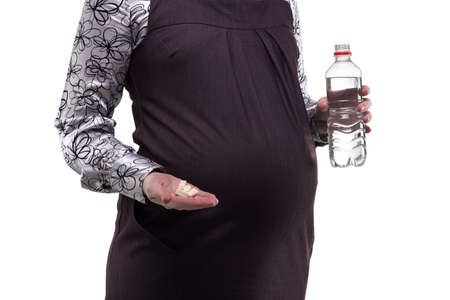 Pregnant woman and vitamins on white backgroundの写真素材