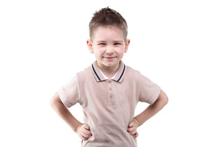 Smiling little boy with hands on hips on white background