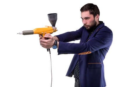 Focused man with powder gun on white backgroundの写真素材