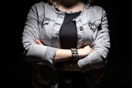 Young woman's arms crossed on black backgroundの写真素材