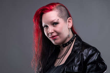 Frick woman in leather jacket on gray background