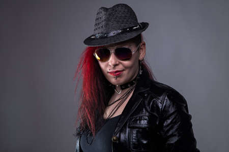 Rock woman in black hat on gray backgroundの写真素材