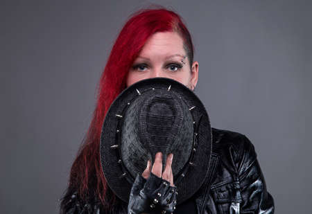 Shy rock woman in black hat on gray backgroundの写真素材