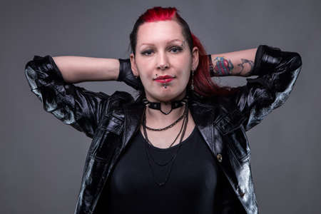 Rock woman with hands up on gray backgroundの写真素材