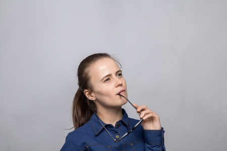 Portrait of thinking woman holding glasses